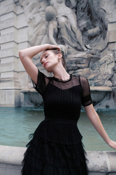 a lady in a black tiered lace dress